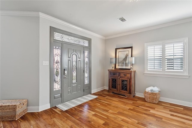 entrance foyer with light hardwood / wood-style floors and crown molding