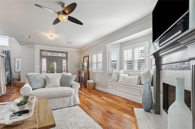 living room featuring hardwood / wood-style floors, ceiling fan, and ornamental molding