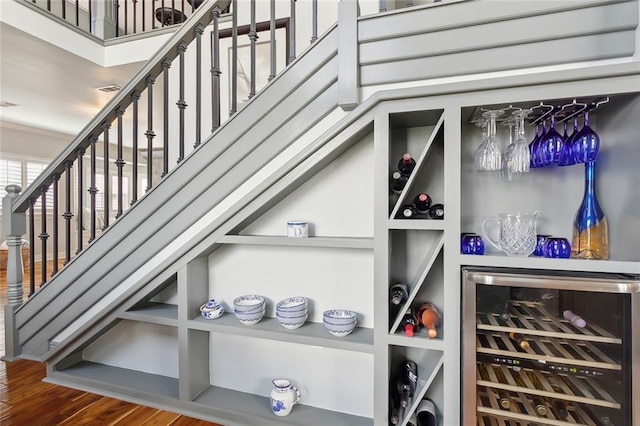 wine cellar with wine cooler and wood-type flooring