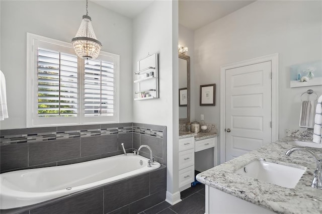 bathroom featuring tiled bath, tile patterned flooring, vanity, and a chandelier