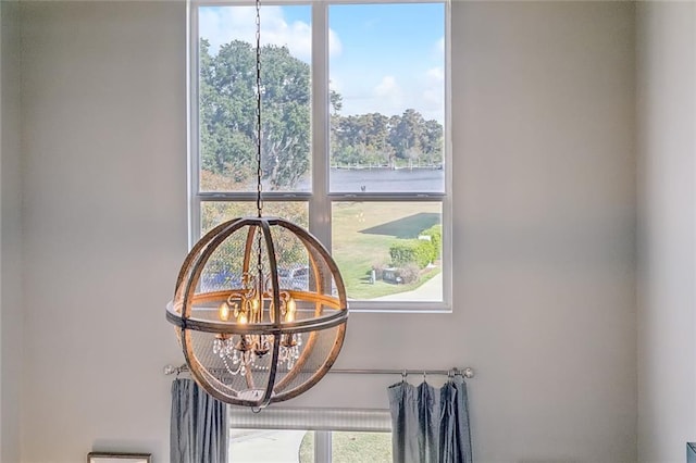 details with a water view and an inviting chandelier