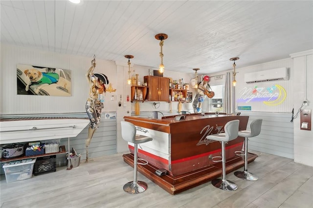 bar featuring wood walls, pendant lighting, light hardwood / wood-style floors, and a wall mounted air conditioner