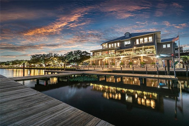 view of dock with a balcony and a water view