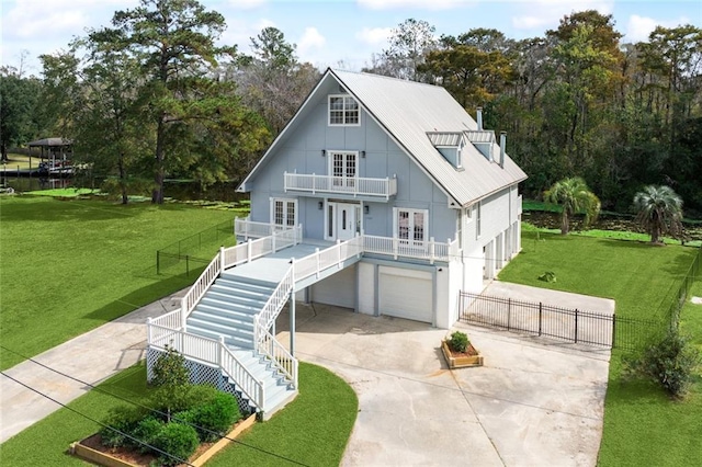 view of front of property featuring board and batten siding, driveway, french doors, a balcony, and stairs