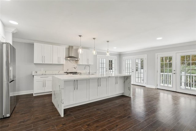 kitchen with baseboards, wall chimney exhaust hood, french doors, and freestanding refrigerator