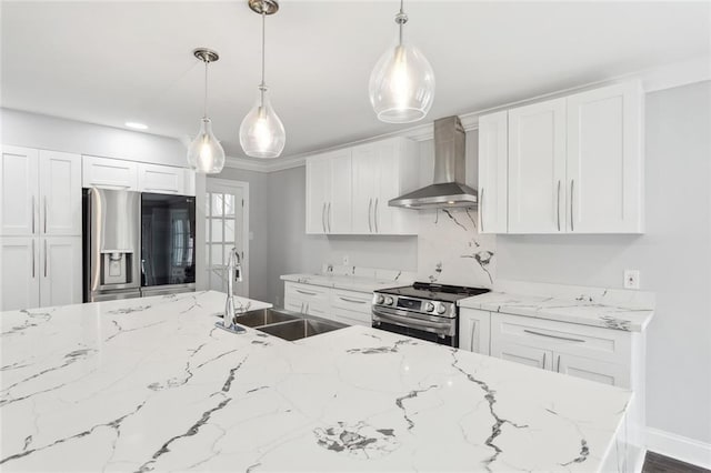 kitchen featuring light stone countertops, a sink, wall chimney range hood, white cabinets, and appliances with stainless steel finishes