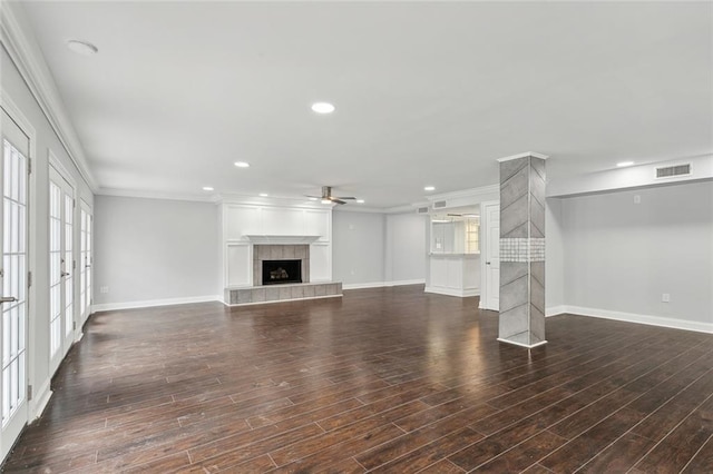 unfurnished living room with crown molding, visible vents, baseboards, a fireplace, and a ceiling fan