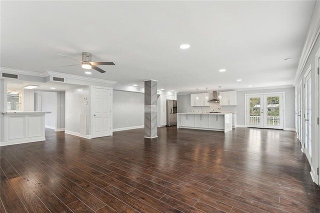 unfurnished living room featuring visible vents, ceiling fan, crown molding, and baseboards