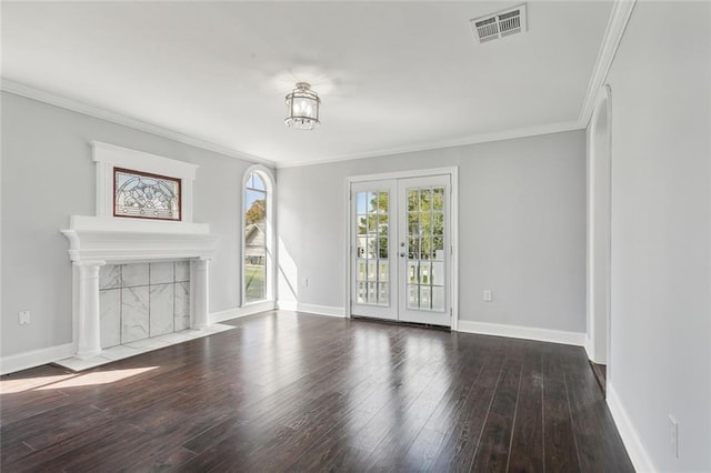 unfurnished living room with ornamental molding, visible vents, wood finished floors, and baseboards
