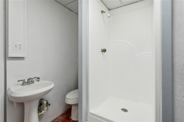 bathroom featuring toilet and a shower stall