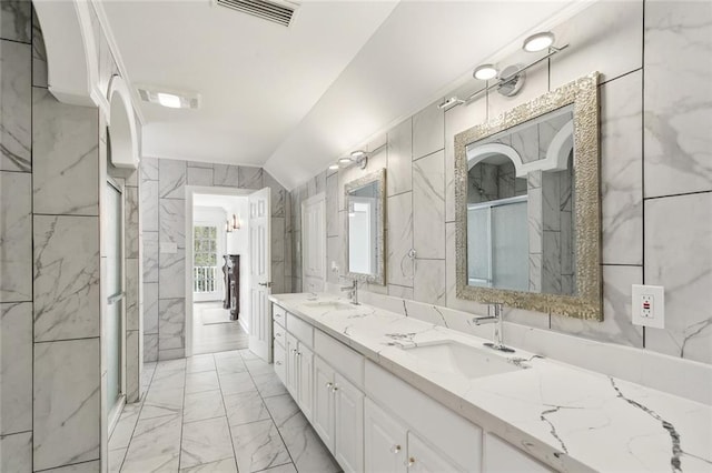 bathroom featuring vanity, tile walls, lofted ceiling, and an enclosed shower