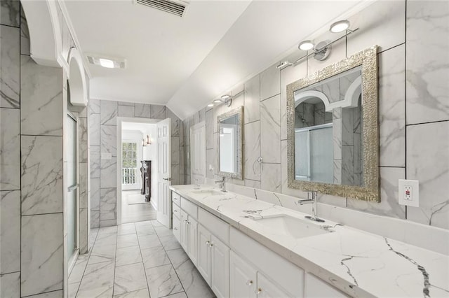 full bath featuring marble finish floor, a sink, double vanity, and visible vents