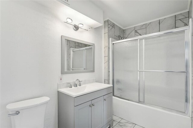bathroom featuring shower / bath combination with glass door, marble finish floor, toilet, and vanity