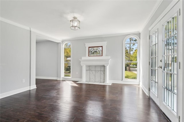 unfurnished living room featuring baseboards, wood finished floors, a tile fireplace, and ornamental molding