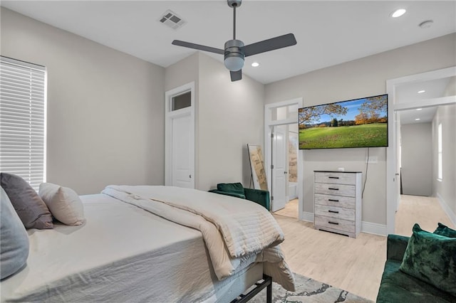 bedroom featuring ensuite bath, light hardwood / wood-style floors, and ceiling fan