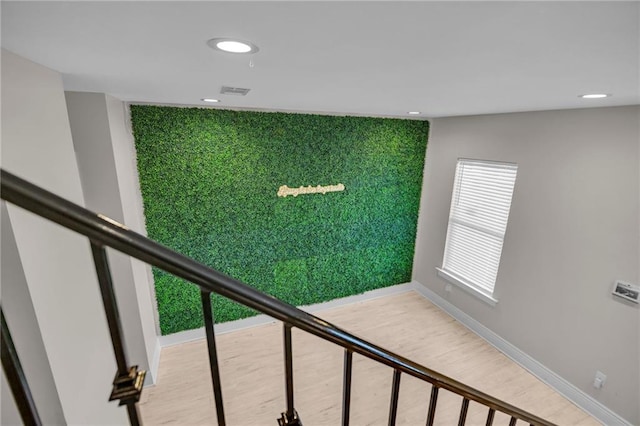 staircase featuring golf simulator and hardwood / wood-style floors