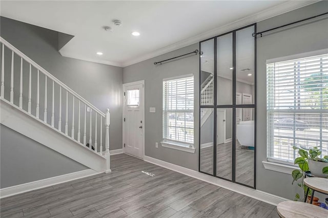 entrance foyer with crown molding and wood-type flooring