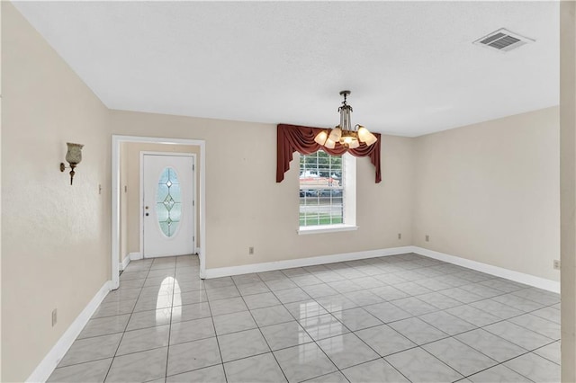 foyer with a chandelier and light tile patterned floors