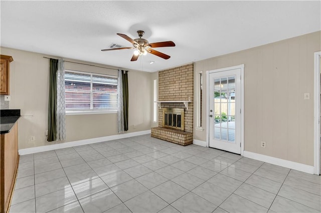 unfurnished living room with ceiling fan, light tile patterned floors, and a fireplace