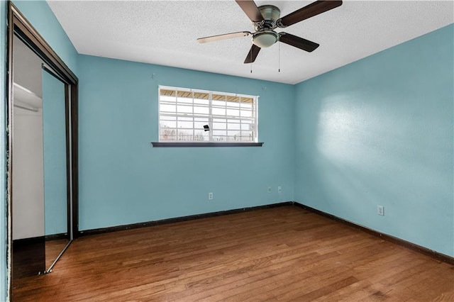 unfurnished bedroom with a closet, hardwood / wood-style floors, a textured ceiling, and ceiling fan