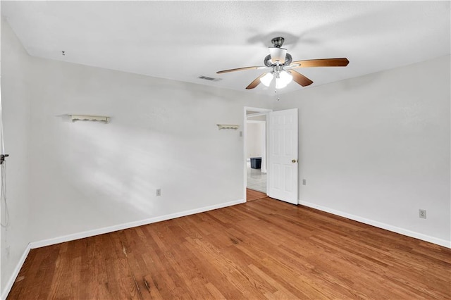 empty room with hardwood / wood-style floors and ceiling fan