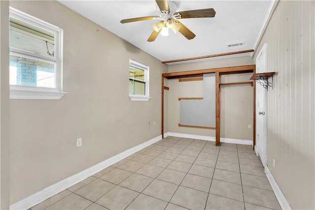 tiled empty room featuring ceiling fan