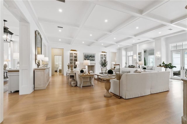 living room featuring beamed ceiling, light hardwood / wood-style floors, a wealth of natural light, and coffered ceiling