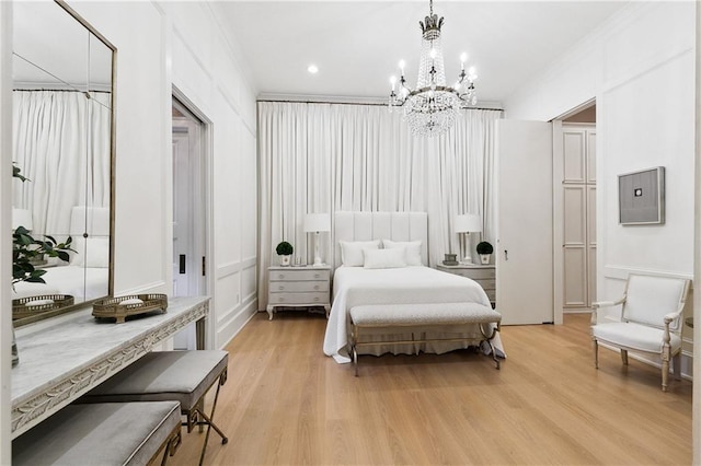 bedroom featuring electric panel, light hardwood / wood-style flooring, ornamental molding, and a notable chandelier