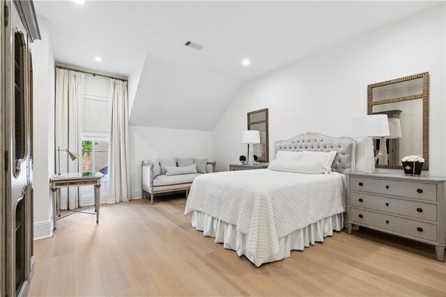 bedroom with light hardwood / wood-style floors and vaulted ceiling