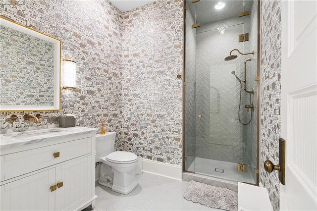 bathroom with tile patterned floors, vanity, a shower with shower door, and toilet