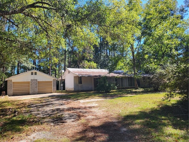 view of front facade featuring an outdoor structure, a front yard, and a garage