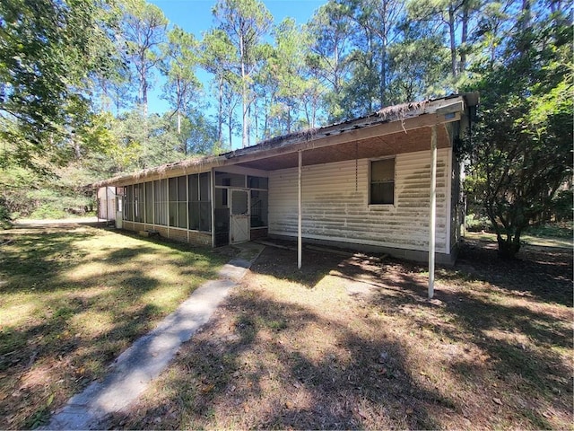 back of property featuring a yard and a sunroom