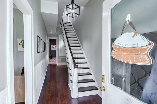 stairway featuring wood-type flooring and a chandelier