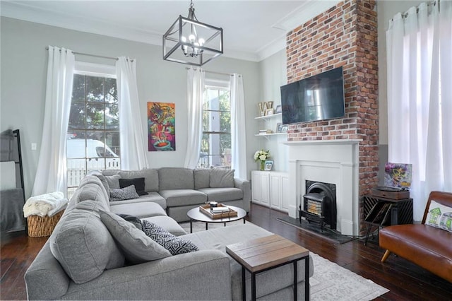 living room featuring ornamental molding, dark hardwood / wood-style floors, and an inviting chandelier