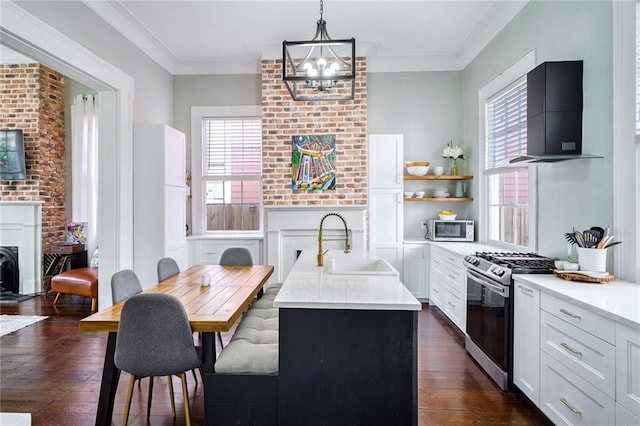 kitchen with stainless steel appliances, range hood, a center island with sink, sink, and pendant lighting