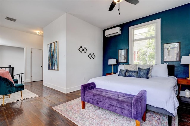 bedroom featuring an AC wall unit, dark hardwood / wood-style floors, and ceiling fan