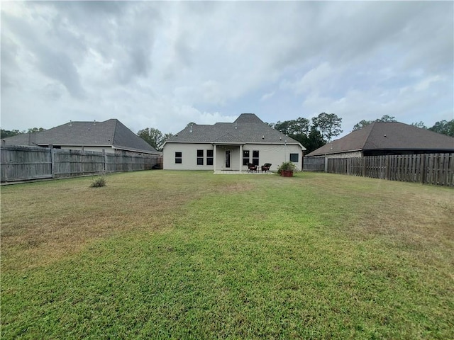 back of house with a yard and a patio area