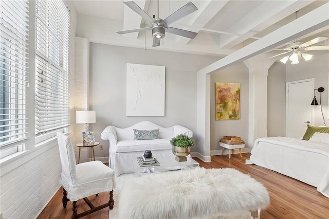 bedroom with beam ceiling, wood-type flooring, coffered ceiling, and ceiling fan