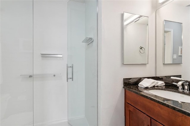 bathroom featuring vanity and a shower with door