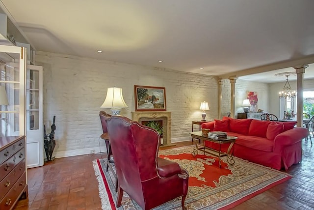 living room featuring an inviting chandelier, parquet floors, and ornate columns