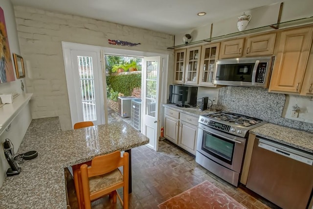 kitchen with light stone counters, appliances with stainless steel finishes, dark hardwood / wood-style flooring, and light brown cabinetry