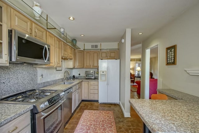 kitchen with light brown cabinetry, sink, appliances with stainless steel finishes, and backsplash