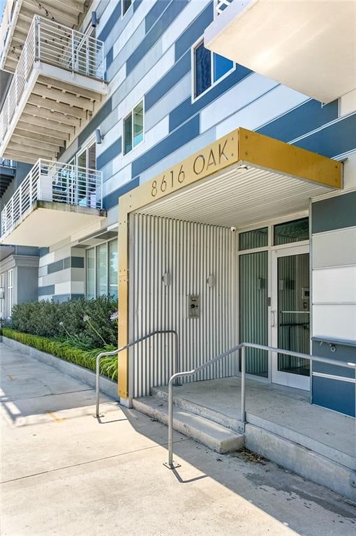 view of exterior entry featuring a balcony