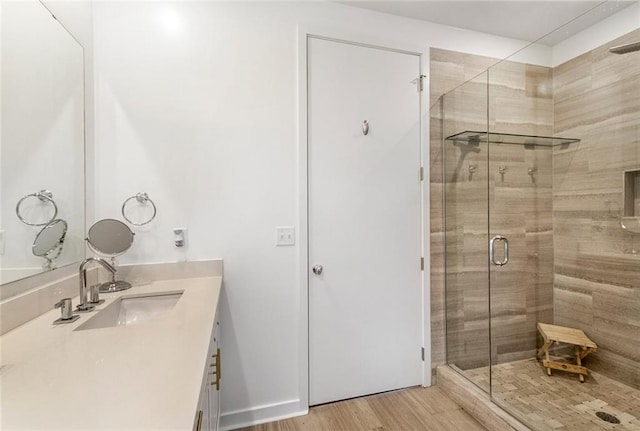 bathroom with vanity, an enclosed shower, and hardwood / wood-style flooring