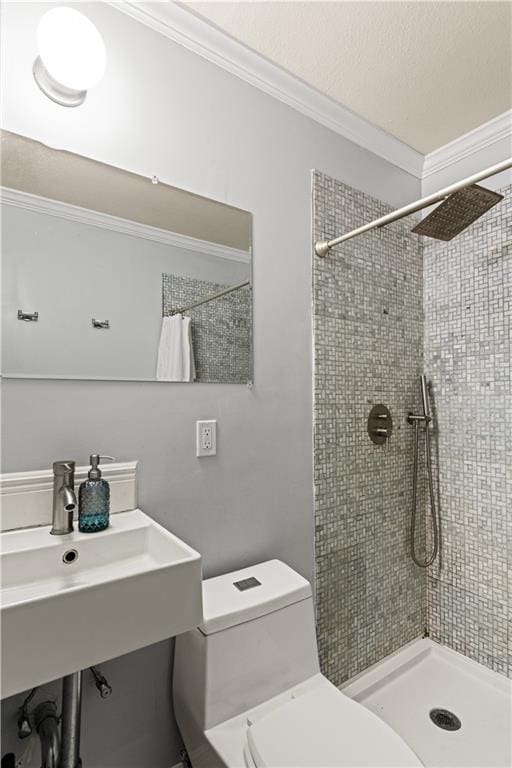 bathroom featuring toilet, crown molding, sink, and tiled shower