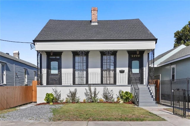 2835 Danneel St, New Orleans, LA 70115 - view of front of house with covered porch, roof with shingles, and a chimney