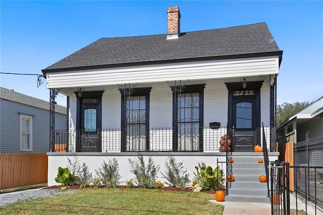 2835 Danneel St, New Orleans, LA 70115 - view of front facade with covered porch, fence, roof with shingles, and a chimney