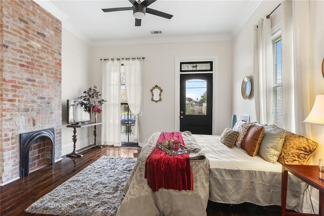 bedroom featuring crown molding, a fireplace, dark hardwood / wood-style floors, and ceiling fan