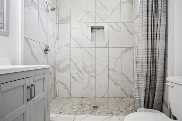 bathroom with toilet, vanity, and walk in shower