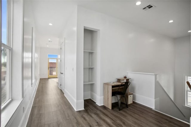 hallway featuring dark hardwood / wood-style flooring and built in shelves